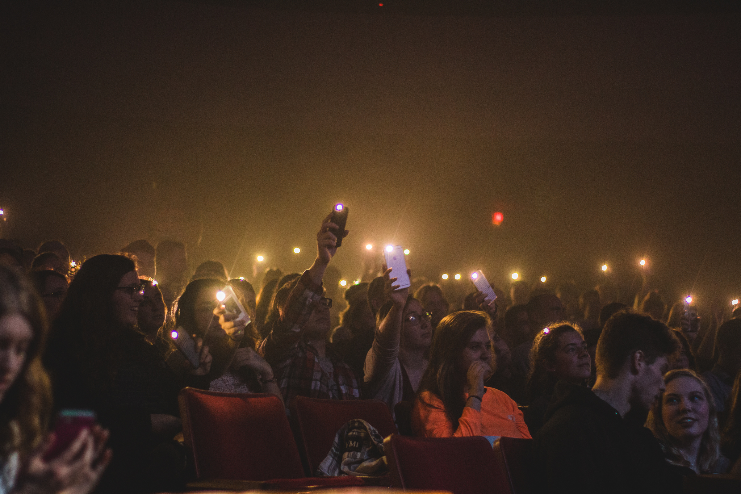 Photo of People Holding Smartphones With Flashlight